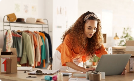 Petite entreprise, entrepreneur et jeune femme travaillant avec un stock de vêtements dans un magasin