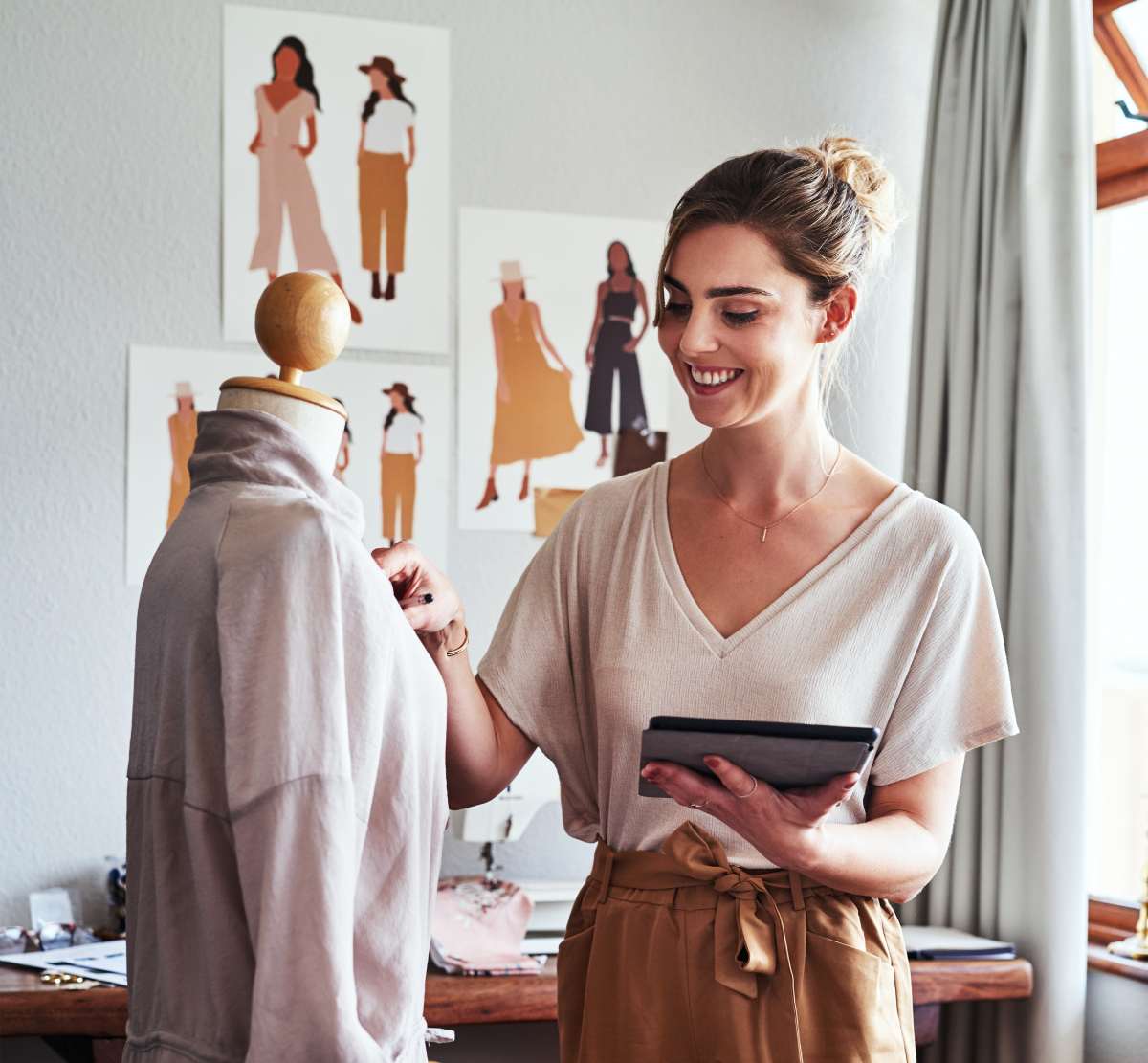 Fashion designer reviewing her work on a tablet in her studio